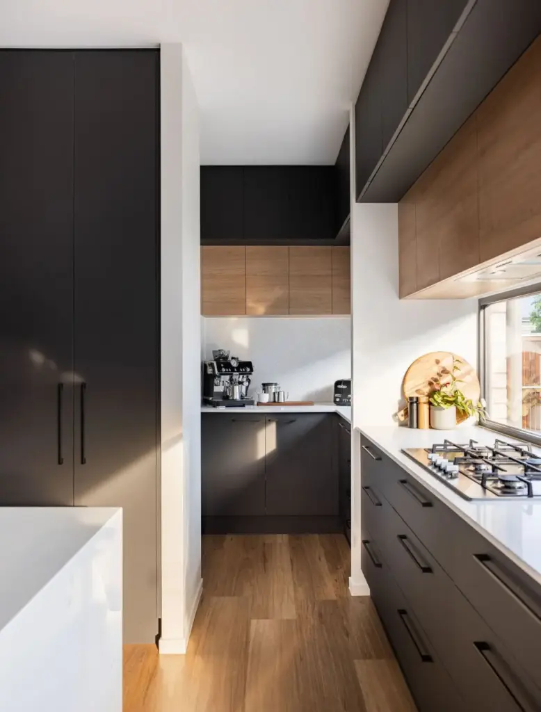 Galley kitchen with black and timber cabinetry, gas cooktop and walk-in pantry